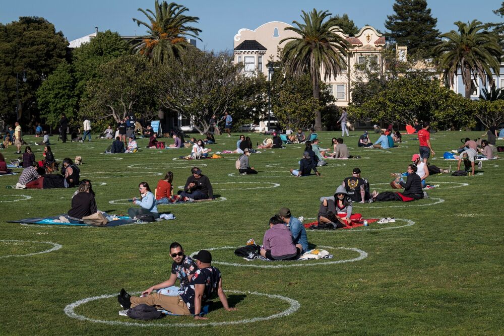 People lay on the grass in circles drawn to promote social distancing at Dolores Park in San Francisco, California, U.S.