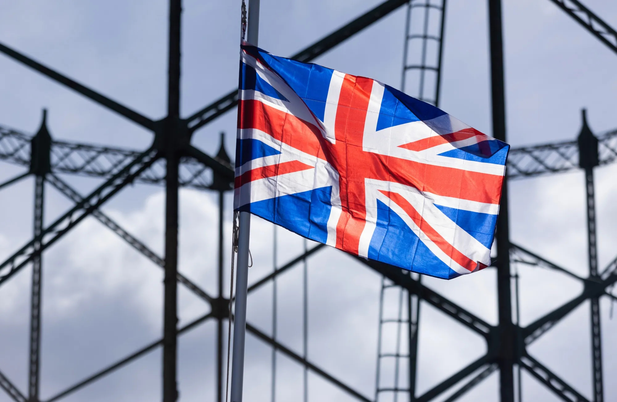 A Union flag flies in front of a disused gasholder near London.