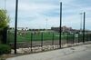 "Field of Dreams" Rugby game between Ohio State University and the University of Minnesota on a manacured field behind a low parapet of stones and metal fencing