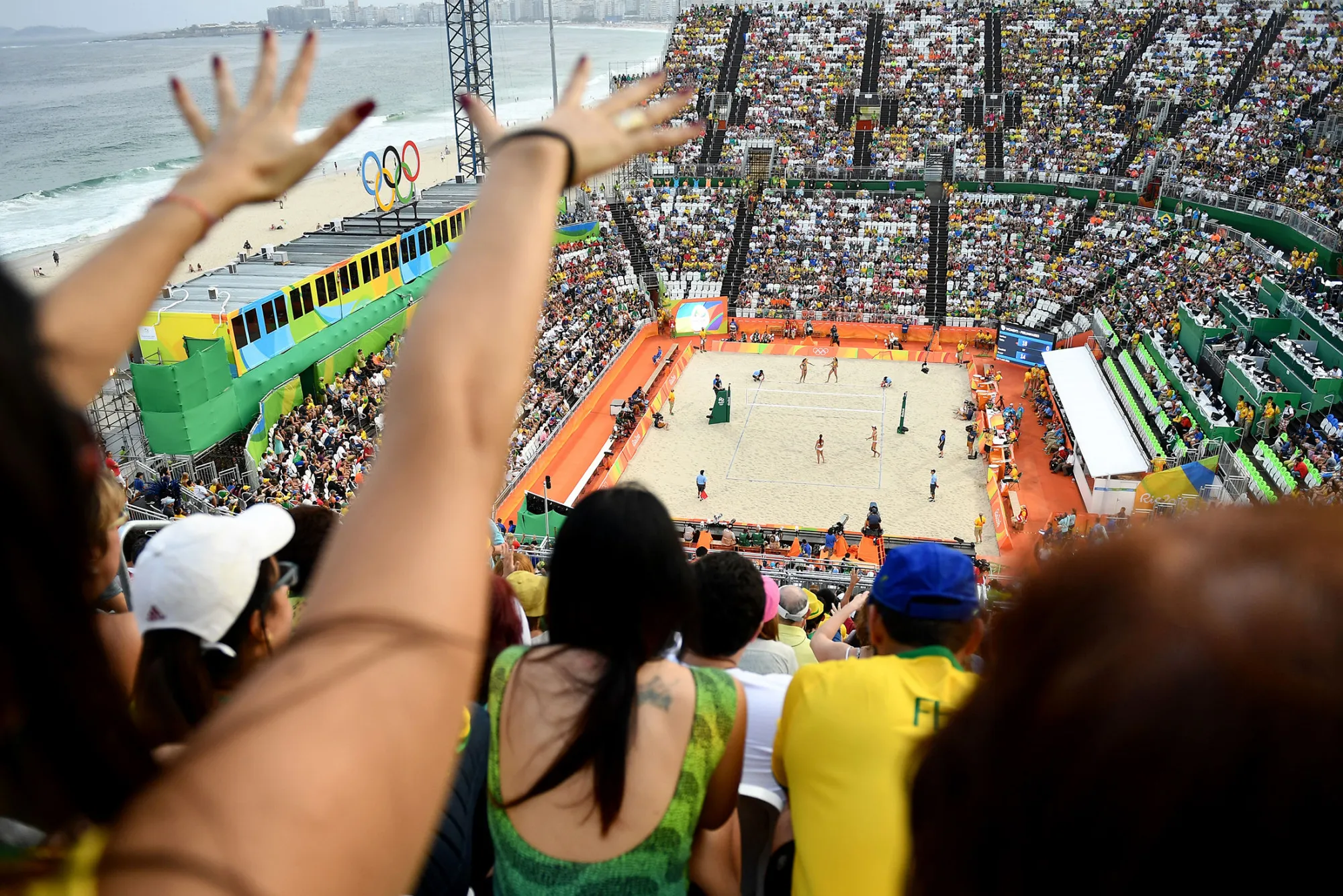 Supporters cheer for their team during the women's beach volleyball qualifying match between Brazil and the USA at the Beach Volley Arena in Rio de Janeiro on August 9, 2016.
