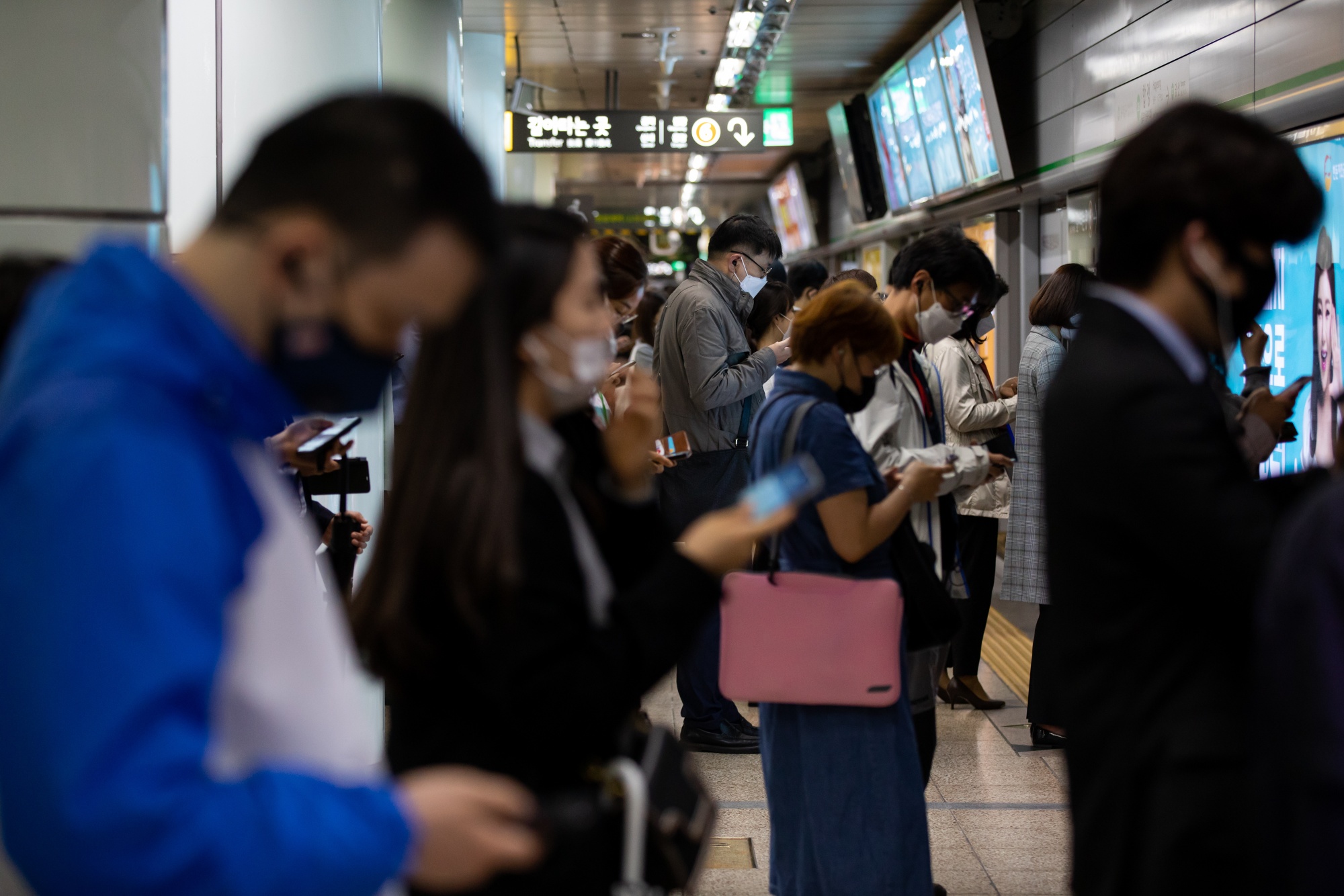 Passengers wearing protective masks wait in line on a platform inside a subway station in Seoul on May 18.