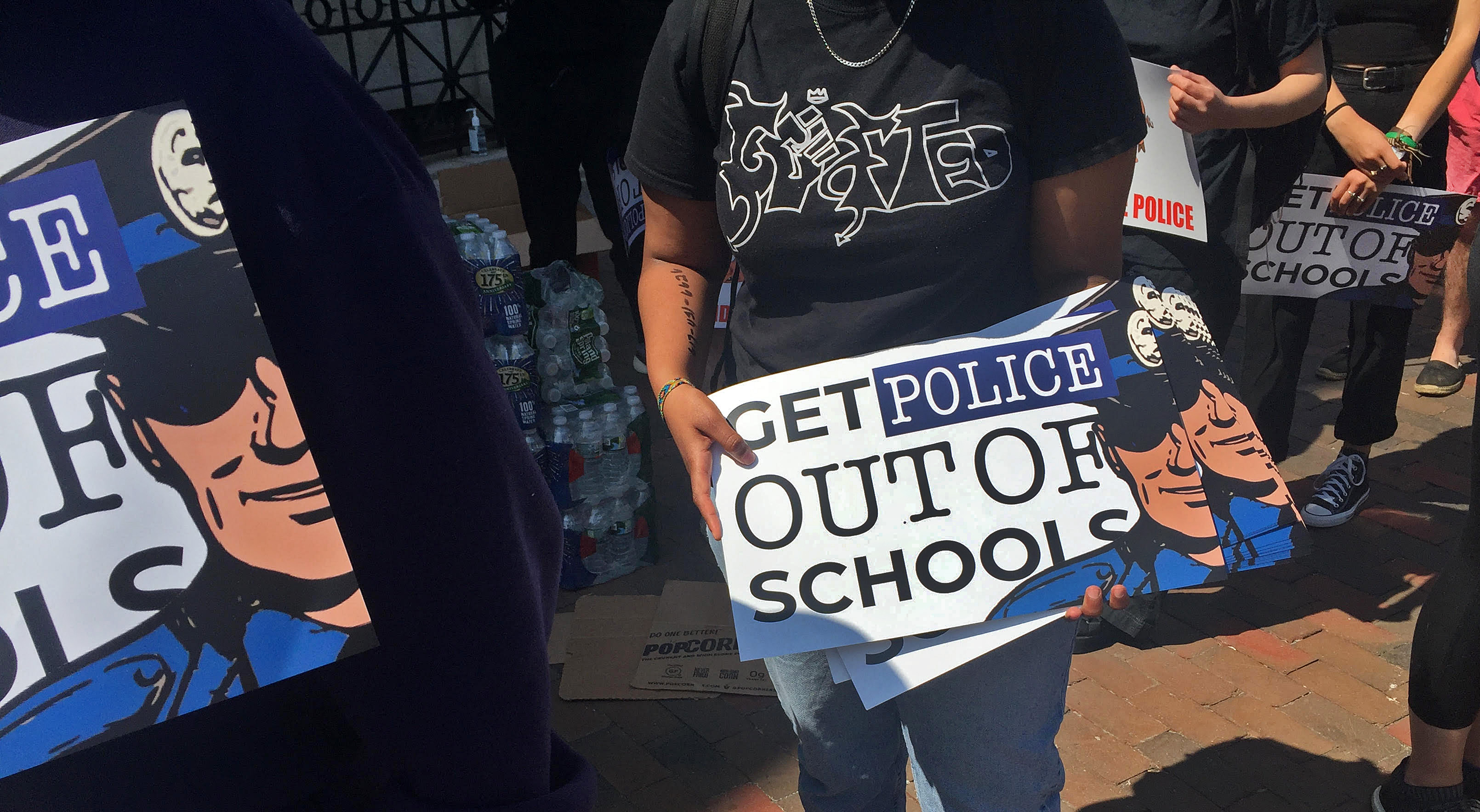 An activist hands out posters calling for the removal of police officers from schools during&nbsp;a youth protest in Boston on June 10.&nbsp;