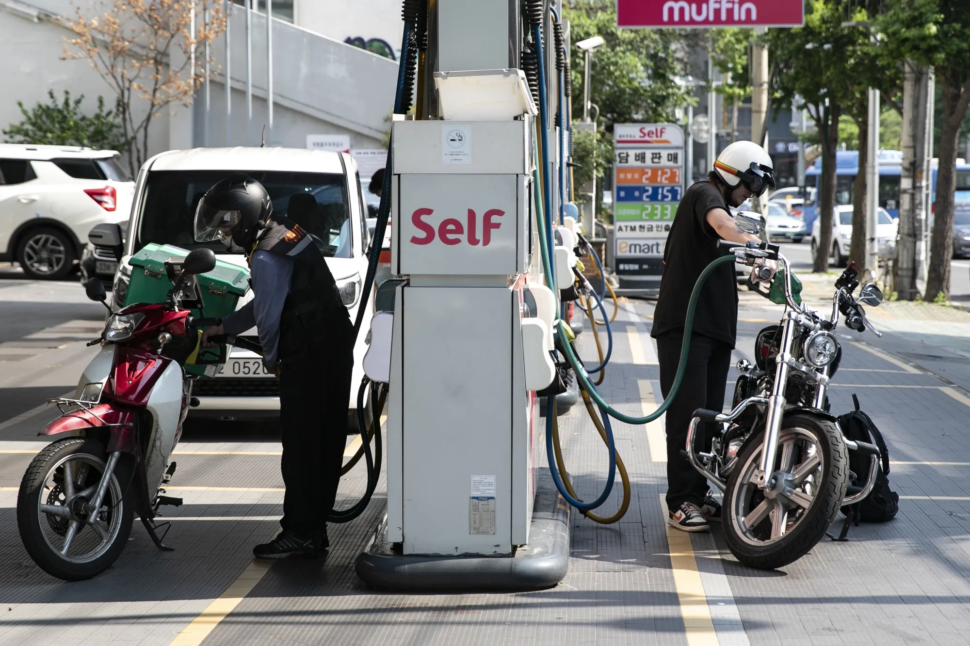 Riders refuel their motorbikes at a gas station in Seoul.