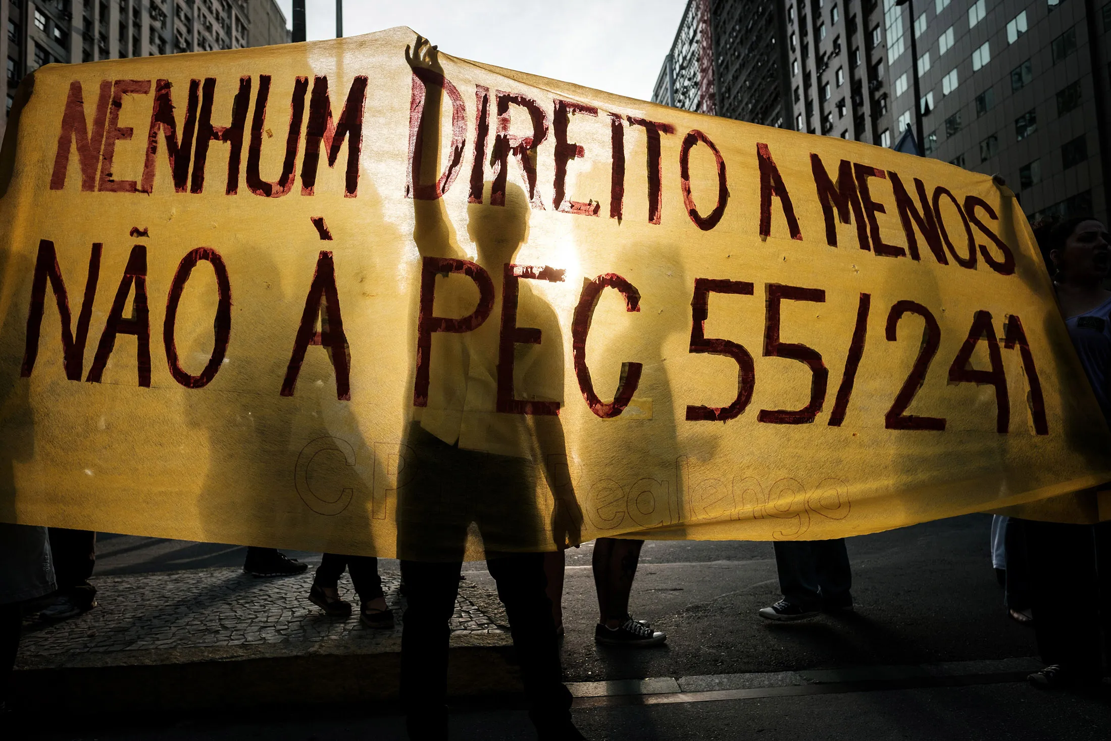 TOPSHOT - Protesters hold a banner against the constitutional amendment (PEC) 55, previously called 241, which limits budget increases to the rate of inflation for the next 20 years, during the nation-wide demonstration againt Temer's government in Rio de Janeiro, Brazil, on November 11, 2016. / AFP / YASUYOSHI CHIBA (Photo credit should read YASUYOSHI CHIBA/AFP/Getty Images)
