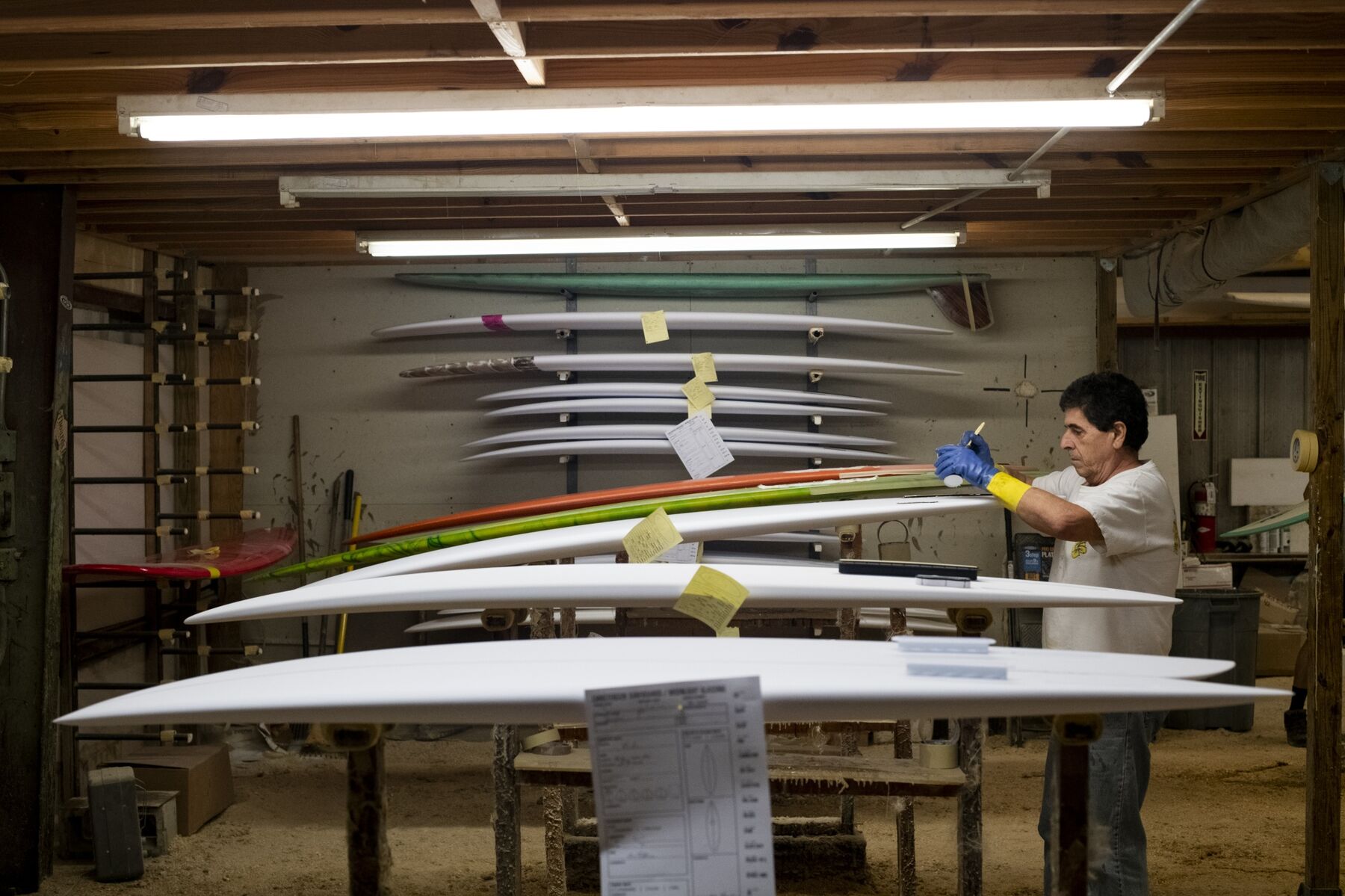 An employee laminates styrofoam shaped blanks with resins at a surboard manufacturing facility in Rockledge, Florida.