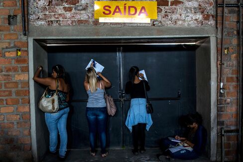 Job seekers fill out applications at an employment fair in Rio de Janeiro, Brazil, on May 18.