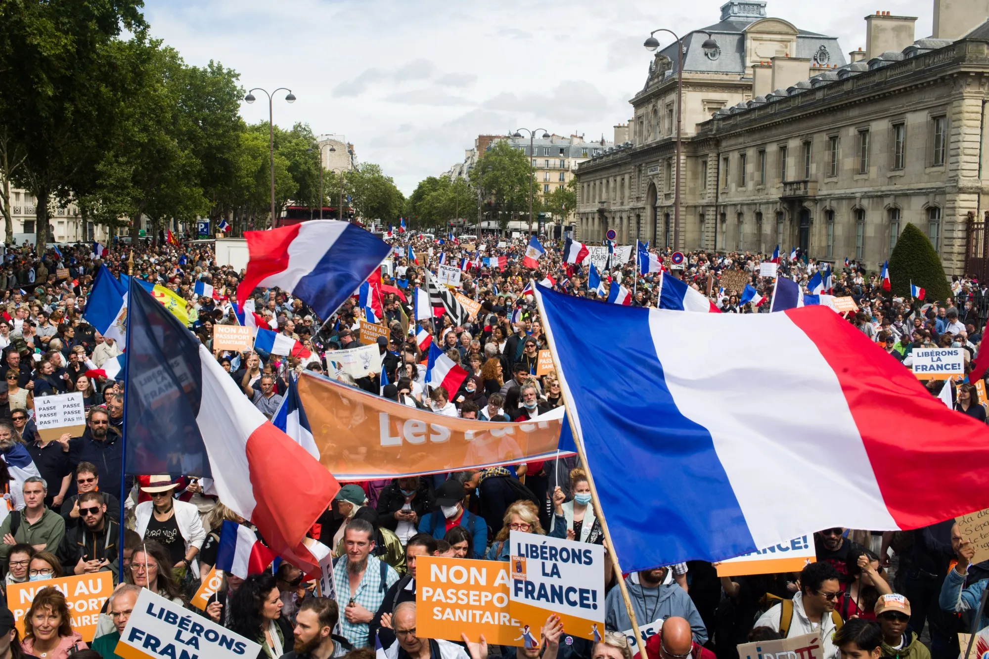 Protesters wave French flags and hold placards near Place Joffre during a demonstration against France's Covid-19 health pass in Paris on&nbsp;Aug. 7.