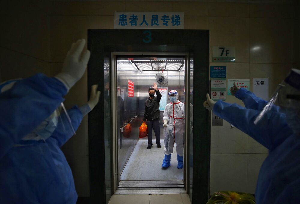 Medical staff wave goodbye to a recovered coronavirus patient at the Red Cross Hospital in Wuhan in China on March 16.