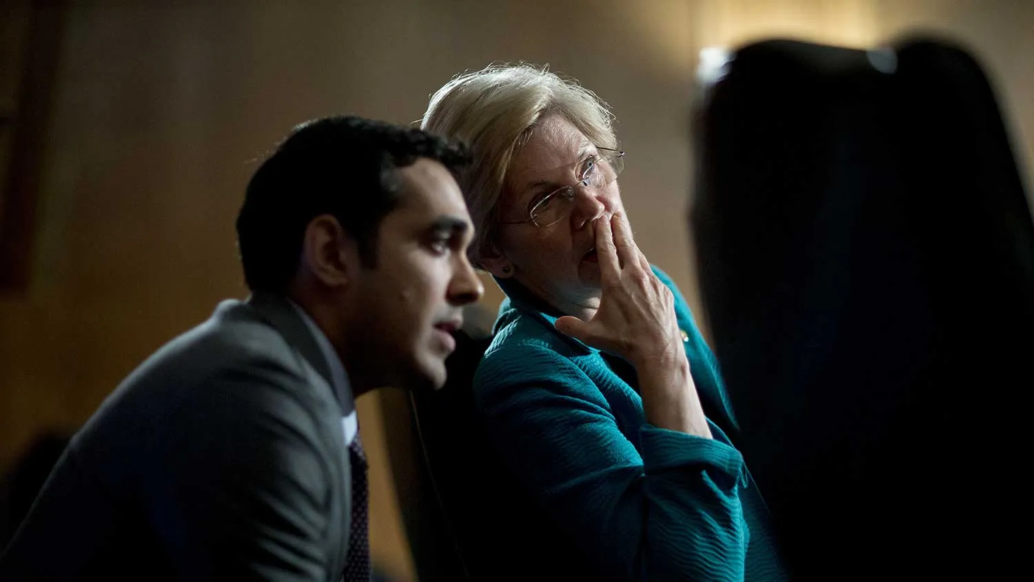 Senator Elizabeth Warren, a Democrat from Massachusetts, center, talks to an aide during a Senate Banking Committee hearing in Washington, D.C., U.S., on Tuesday, July 8, 2014.
