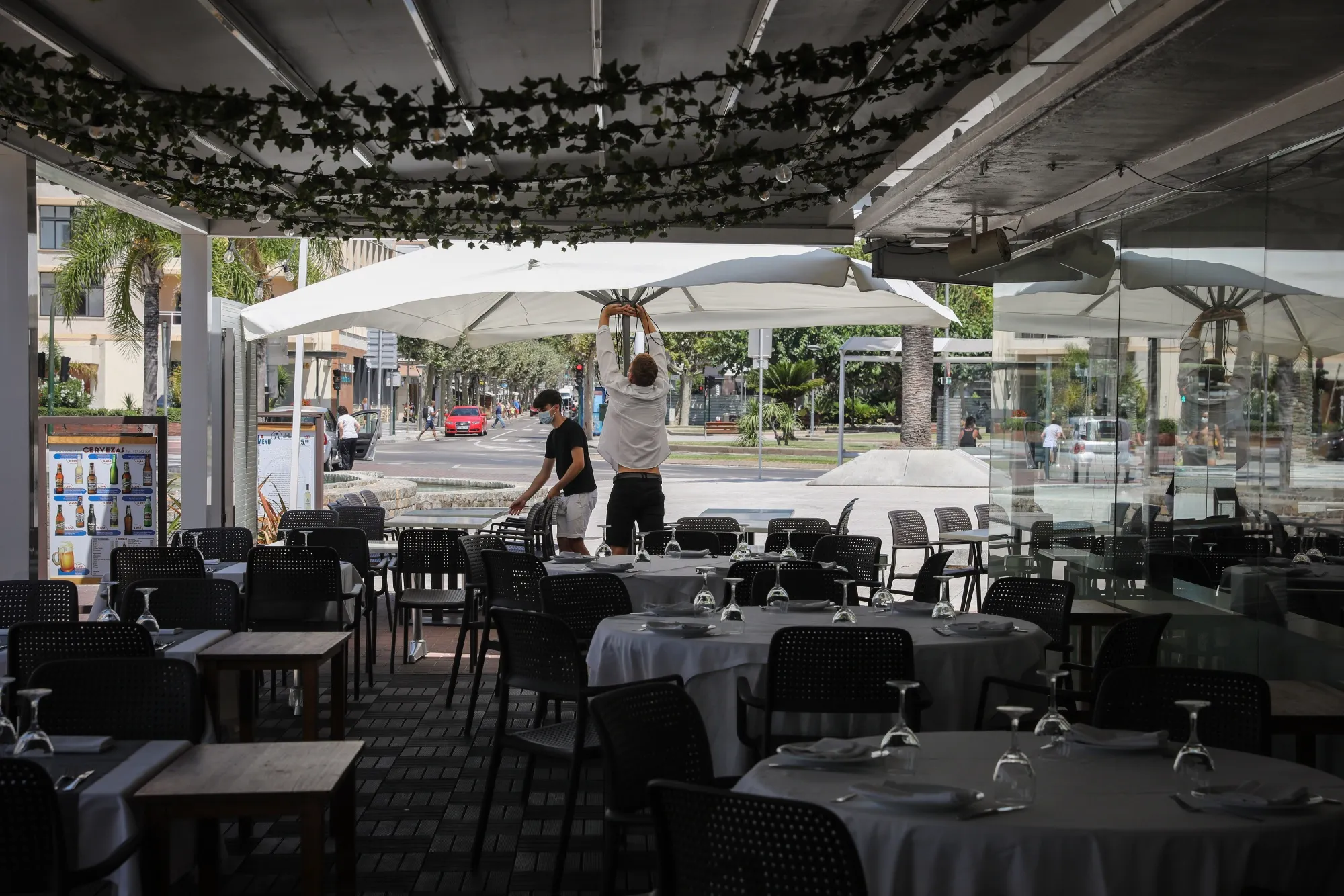 Workers prepare the outdoor terrace area of a restaurant in Salou, Spain, on July 27.