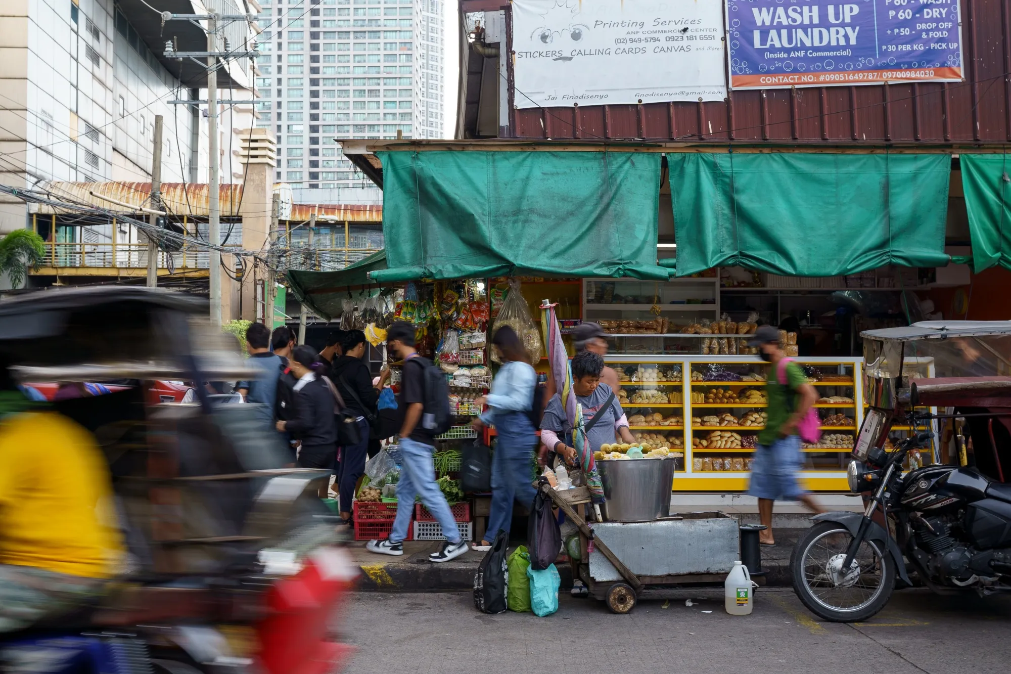 Pedestrians pass a street vendor in Mandaluyong, the Philippines.