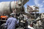 Workers guide a concrete mixer inside the construction site for a building development in Buenos Aires, Argentina, on Friday, Nov. 25, 2016.
