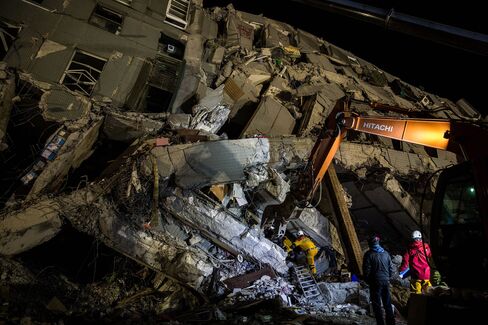 Rescue workers look for survivors in the remains of a building which collapsed in the 6.4 magnitude earthquake, in Tainan, on Feb. 8, 2016.