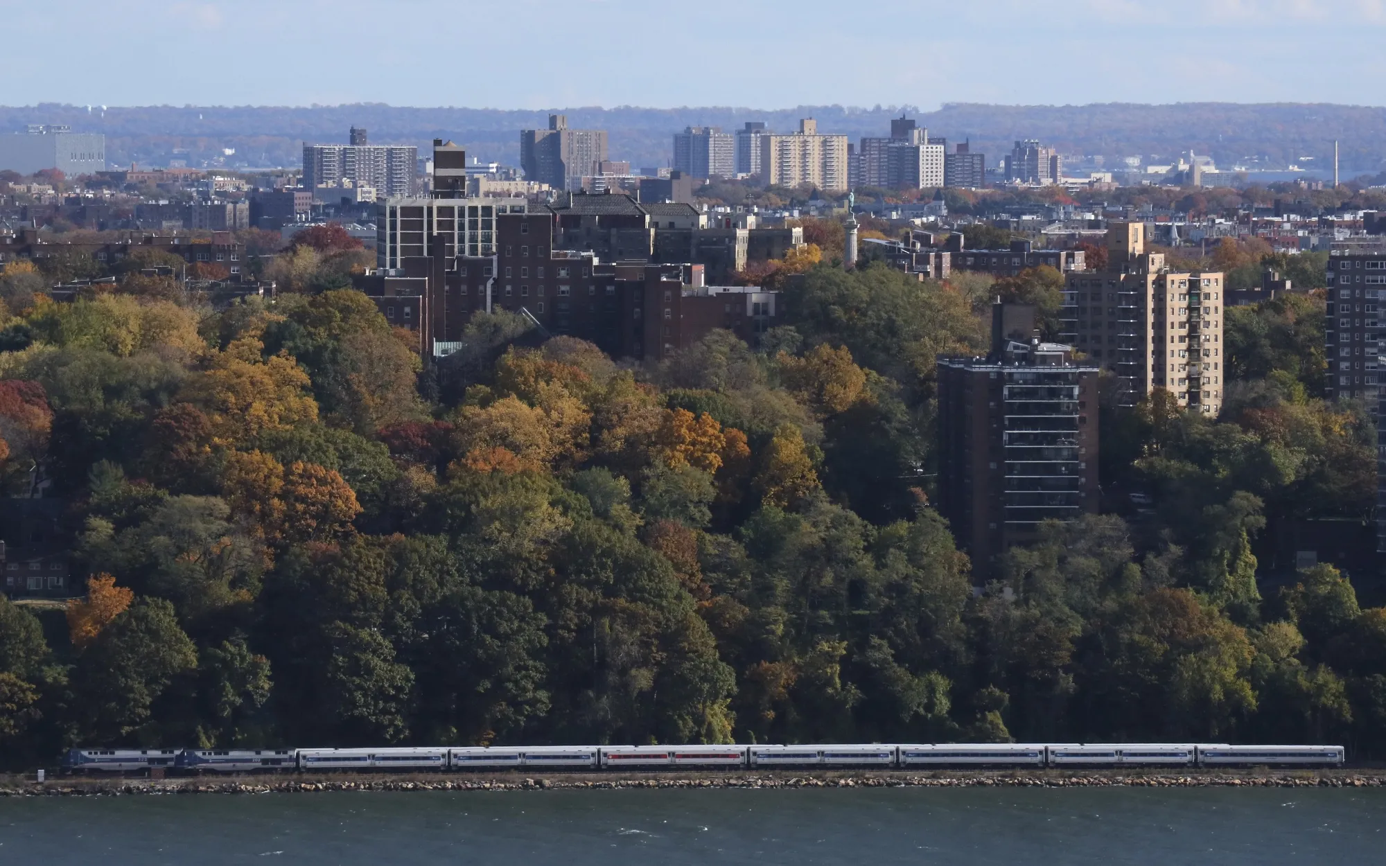 A Metro North train passes along the Hudson River in New Rochelle, NY.