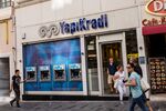 Pedestrians pass a line of automated teller machines outside a Yapi Kredi bank branch in Istanbul.