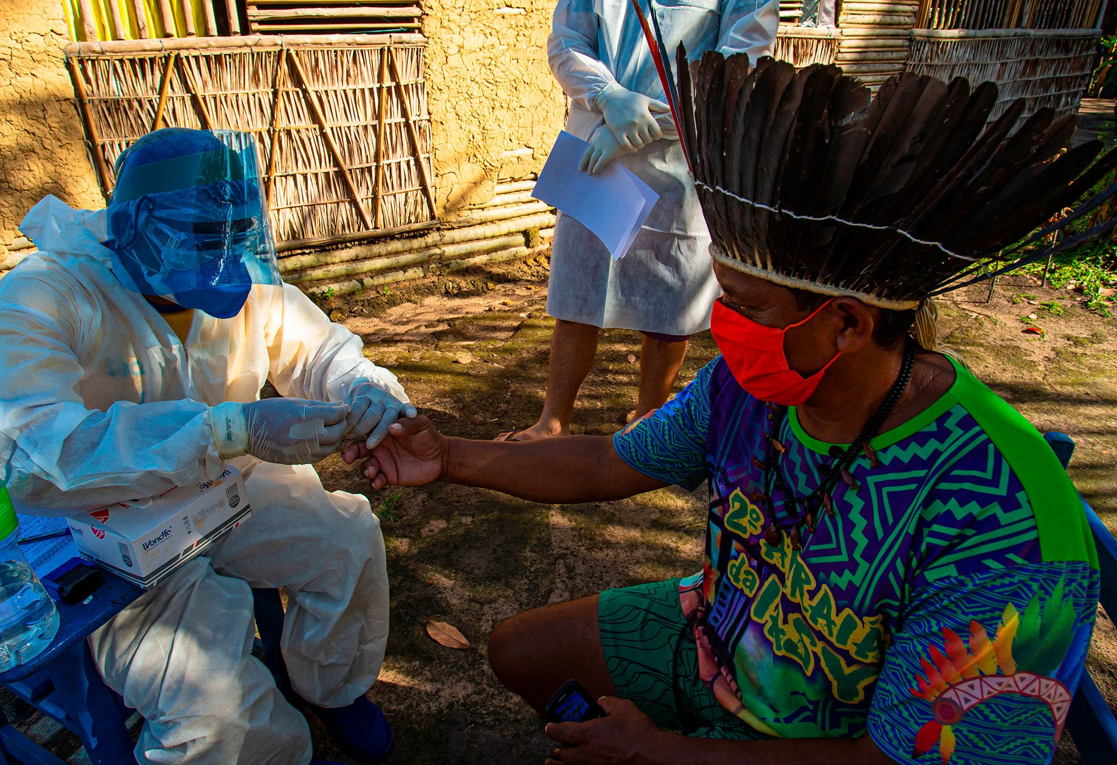 Government health workers perform a rapid Covid-19 test on Chief Leno of the Kunaruara tribe at his village in western Para state, Brazil on July 10.&nbsp;