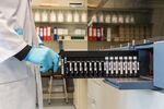 A laboratory worker inserts test tubes into a patient sample analysis machine at UZ Leuven university hospital in Leuven, Belgium.