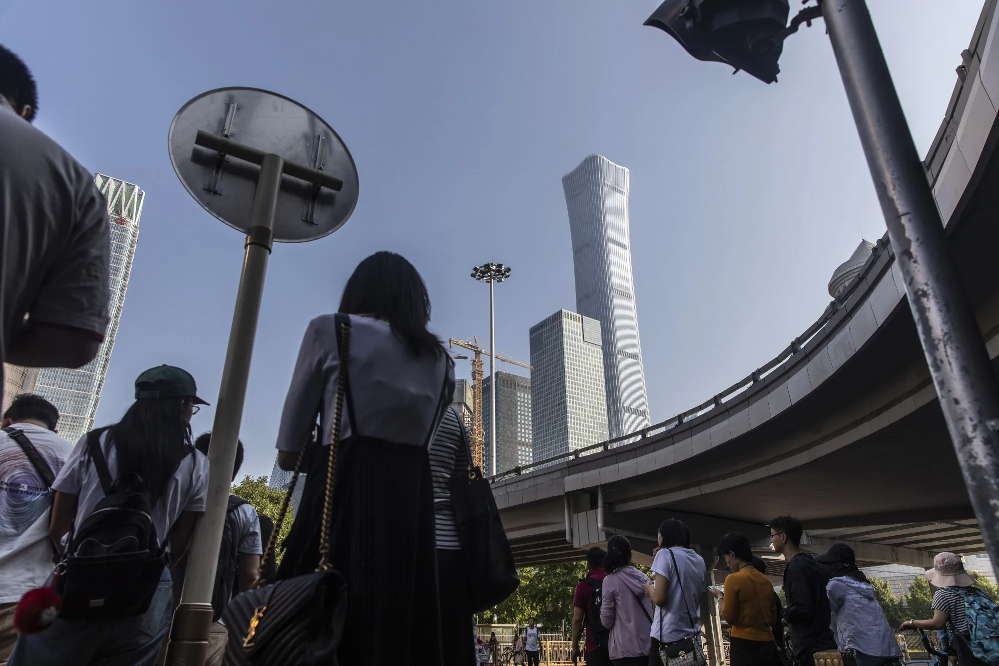Pedestrians wait to cross a road&nbsp;in Beijing.