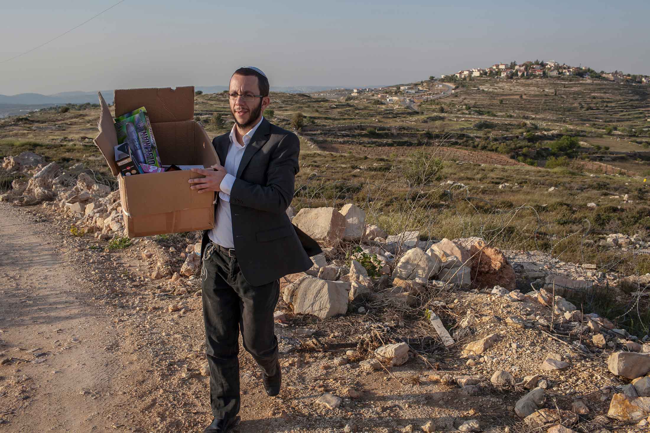 Rabbi Natan Alexander carries a box containing kosher sex toys near his home in Elazar, a Jewish settlement in the West Bank. The rabbi is careful not to expose his small children to the products sold by his e-commerce business, Better2gether, which adheres to Orthodox religious rules by banning nudity, sexy clothing, or any other suggestive imagery.
