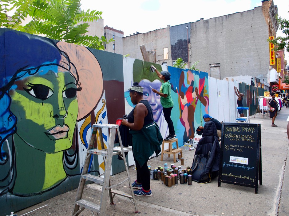 Artists Murjani Holmes and Marthalicia Matarrita paint murals at a long-dormant construction site. With other artists, they are part of a project to decorate the fencing around construction sites as East Harlem awaits funding for a subway extension.