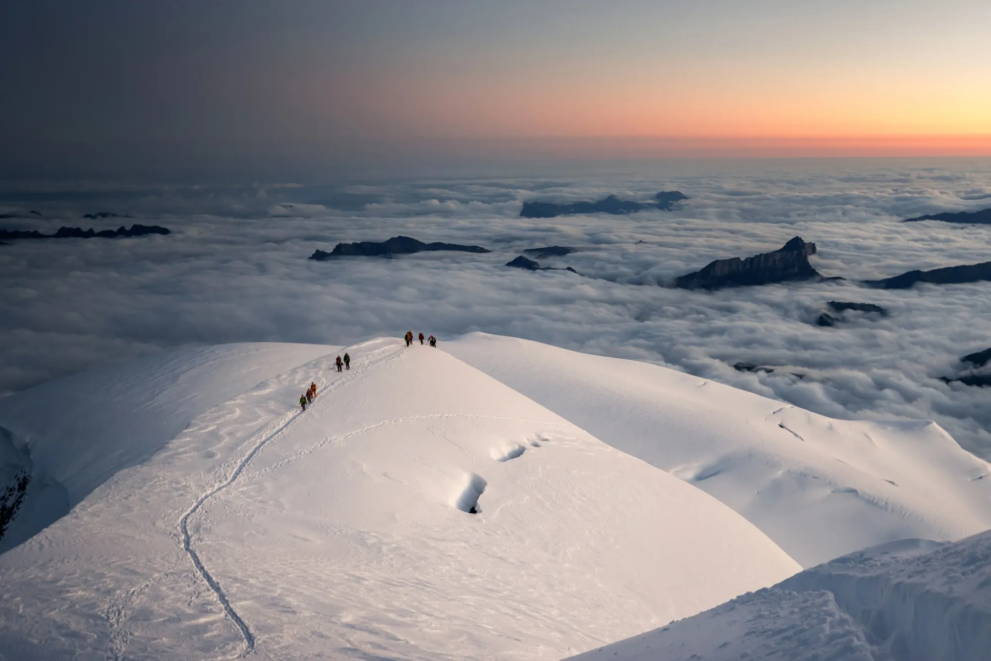 Alpinists at 4,500m on the Arête des Bosses, part of the popular Goûter route to the top of Mont Blanc, at dawn.