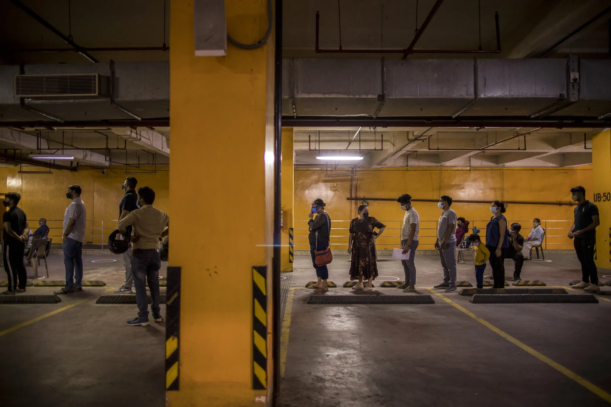 People wait in line at a Covid-19 vaccination center set up in the parking lot of a shopping mall in Noida, Uttar Pradesh on May 31.