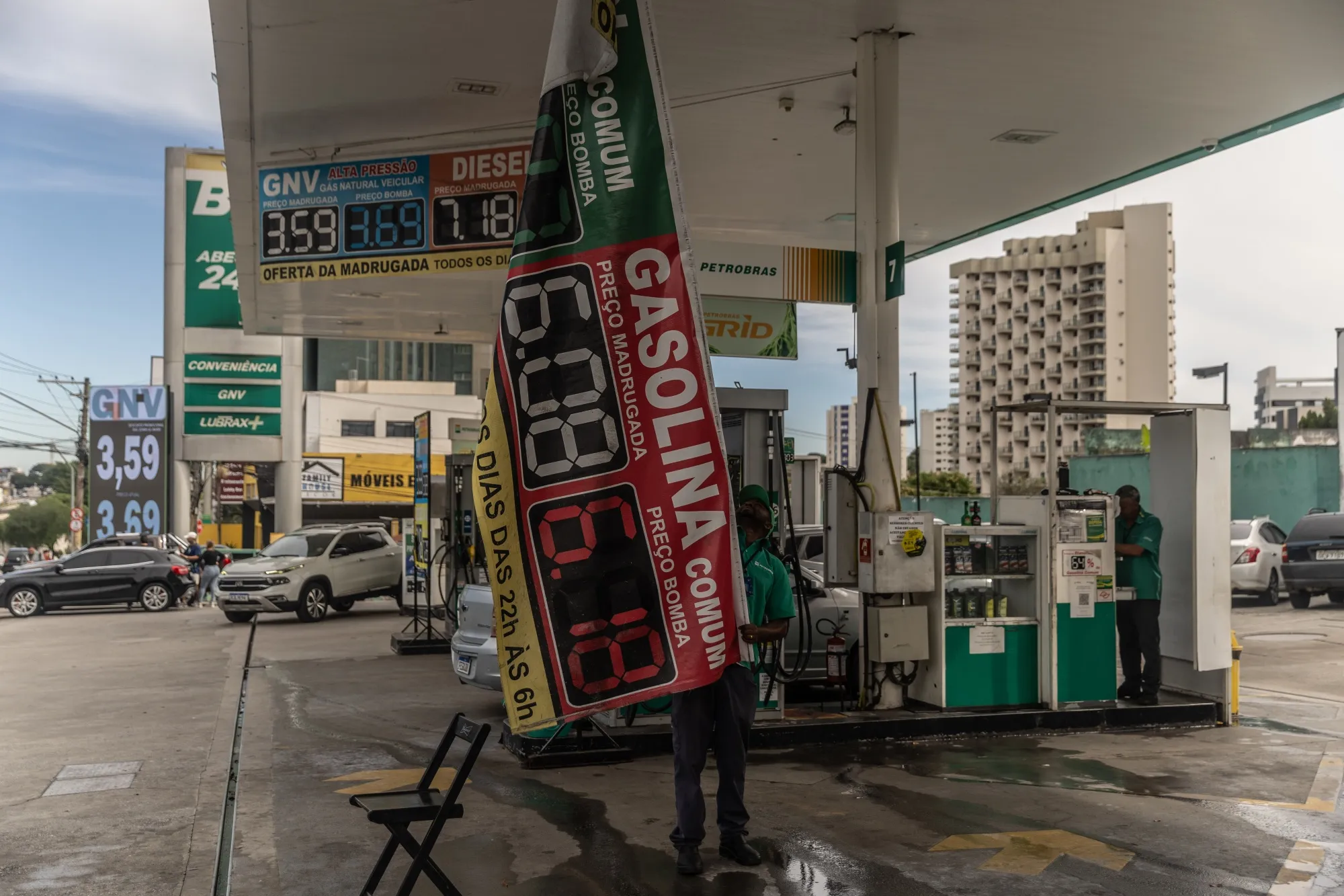 A worker holds a price banner at a Petrobras gas station in Sao Jose dos Campos, Sao Paulo state, Brazil, on&nbsp;May 11.