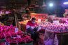 A fruit vendor wearing a protective mask uses a smartphone while waiting for customers at a fresh produce market in Shanghai, China, on Saturday, Feb. 15, 2020. China is entering the "most critical time" in its fight to contain the spreading coronavirus, a government official said.