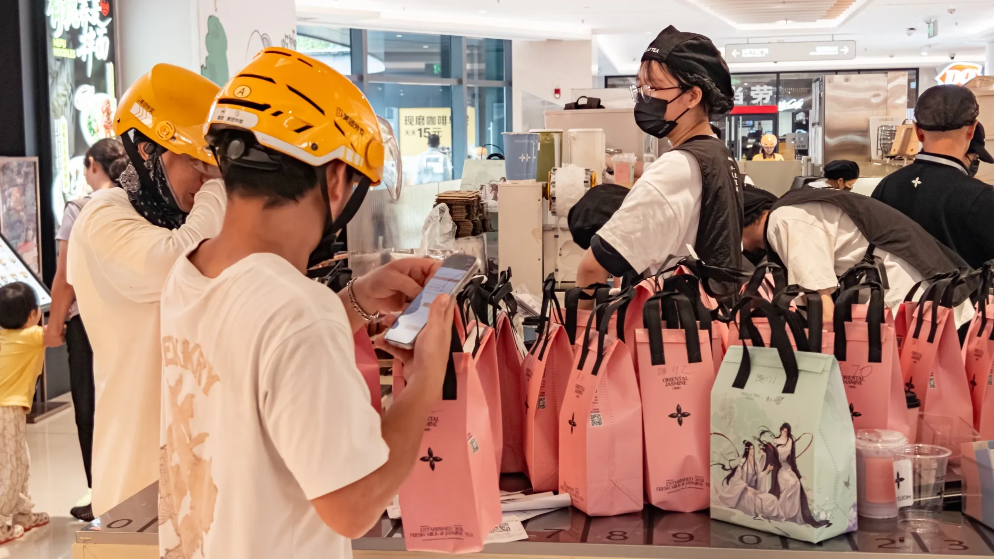 Delivery riders wait at the Mollytea store to pick up orders in Guangdong province.