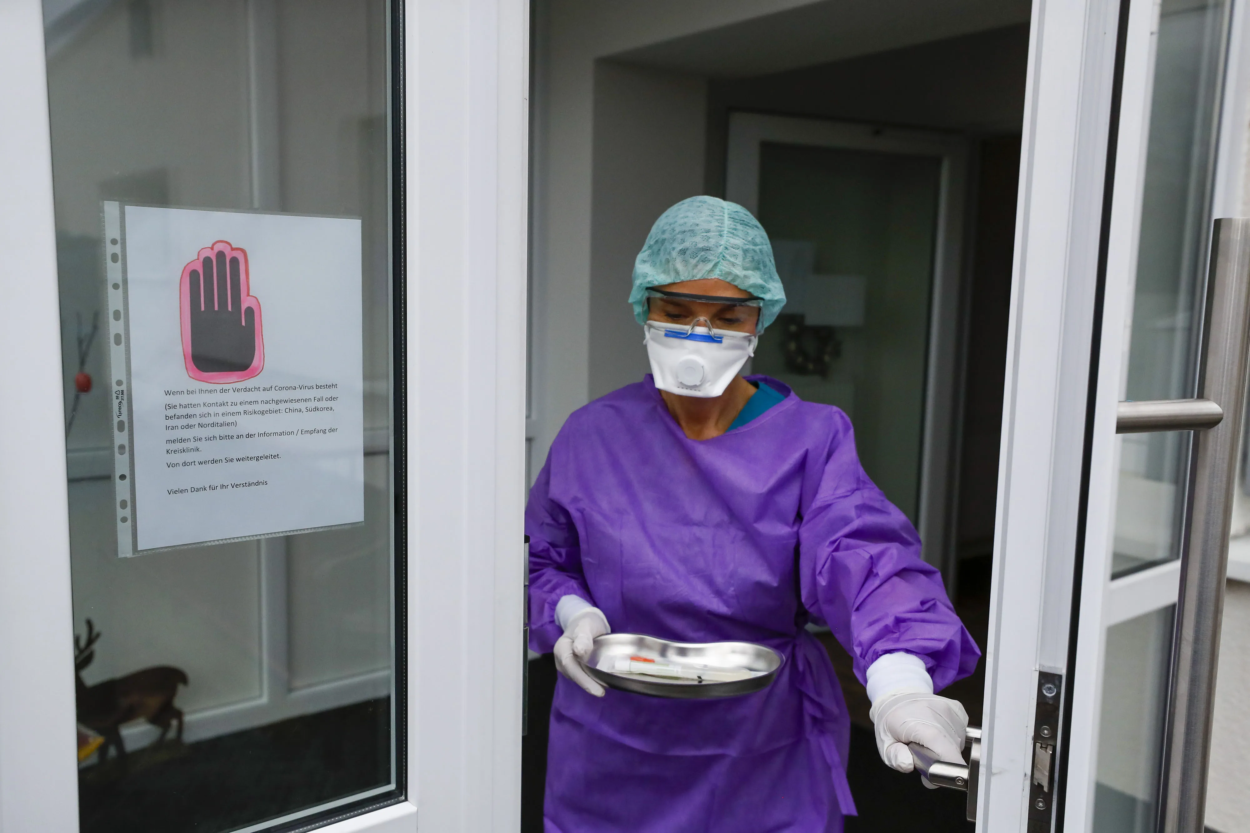 A doctor carries a syringe for coronavirus testing at a drive-in clinic at a hospital in Gross Gerau, Germany.