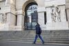 A pedestrian wearing a protective face masks passes the Milan Stock Exchange in Milan, Italy, on Monday, Feb. 24, 2020. 