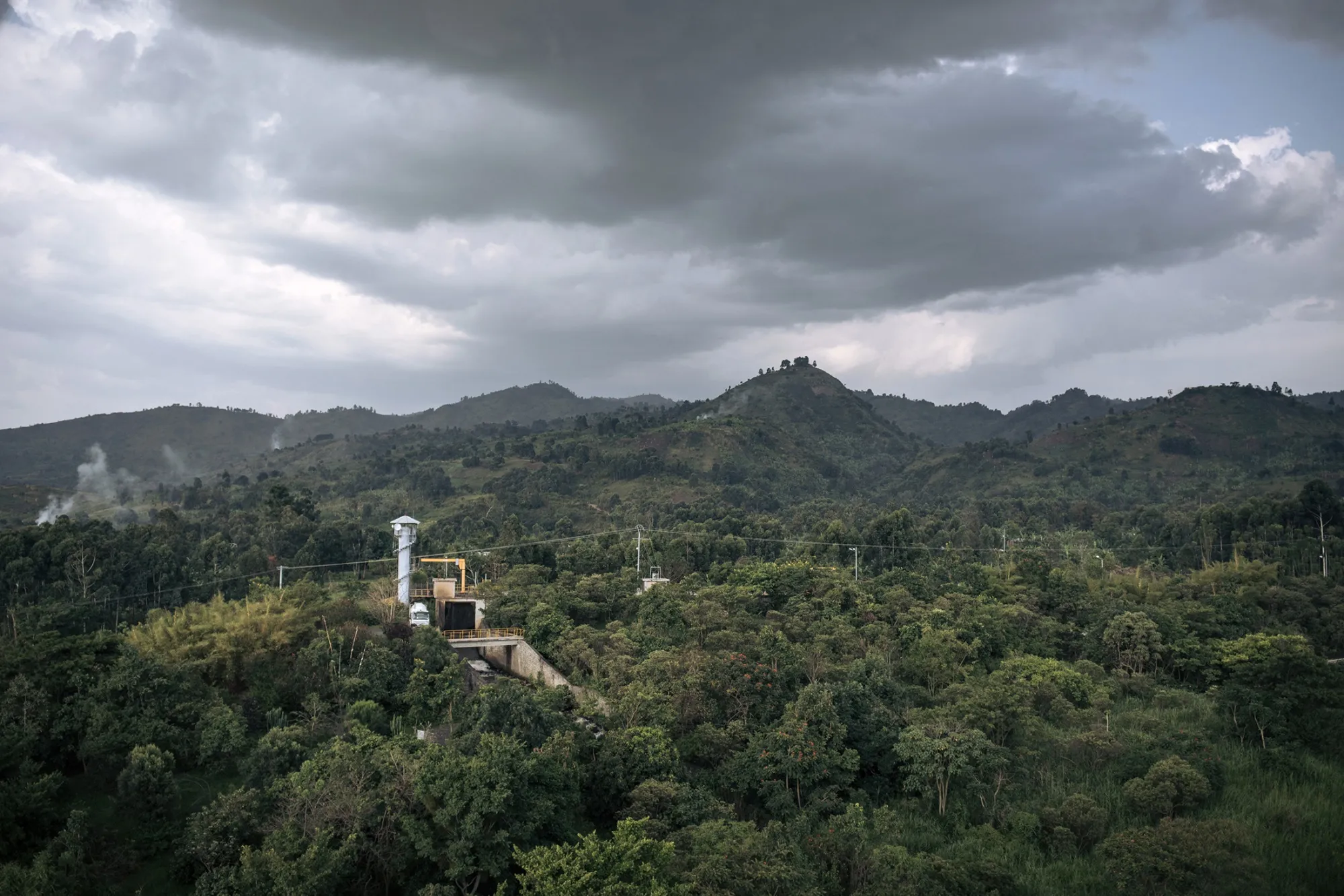 A small hydroelectric power plant surrounded by dense forest and hills in Virunga National Park, Democratic Republic of Congo.