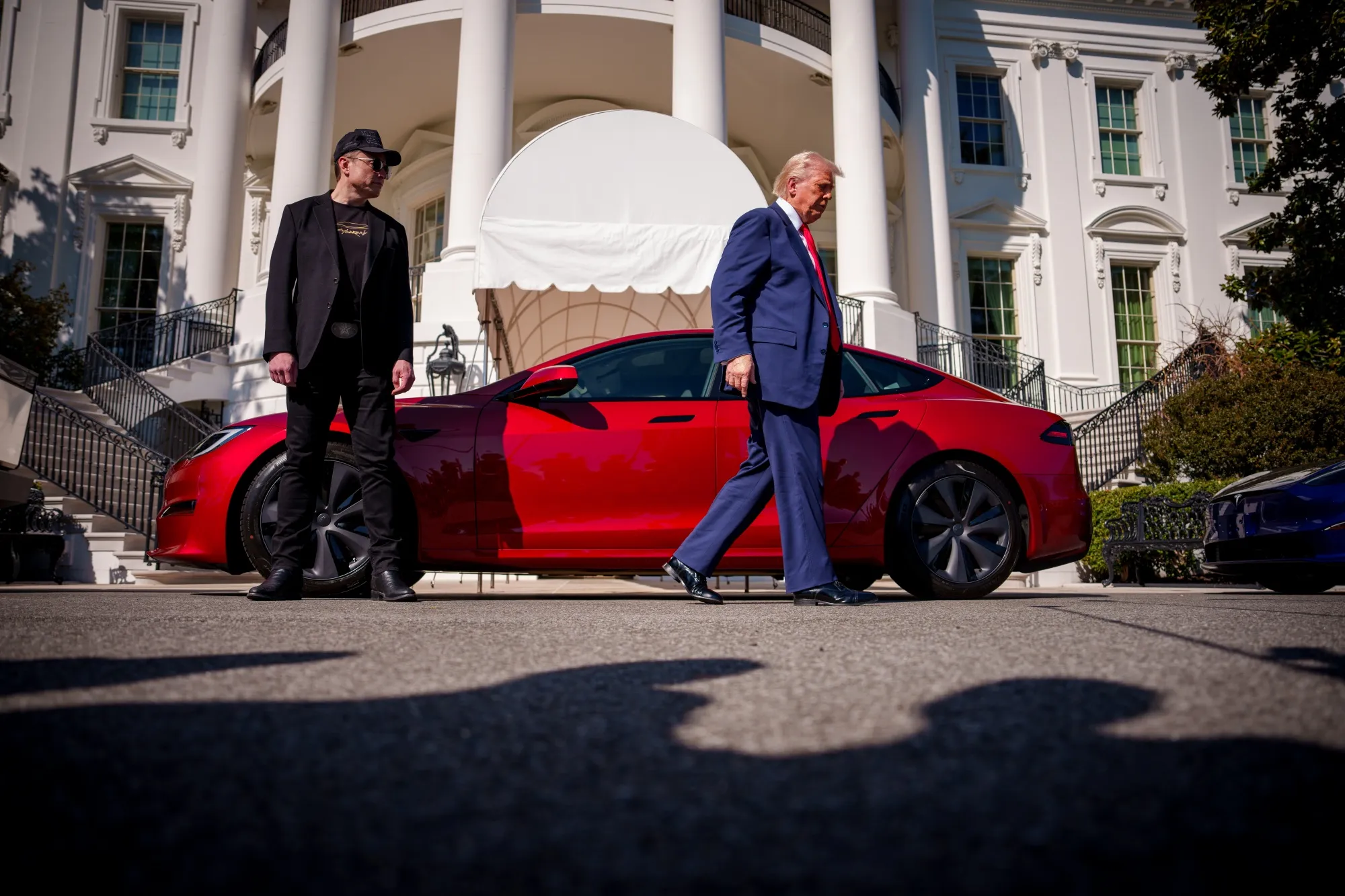 Donald Trump and Elon Musk walk past a Tesla Model S on the South Lawn of the White House on March 11.