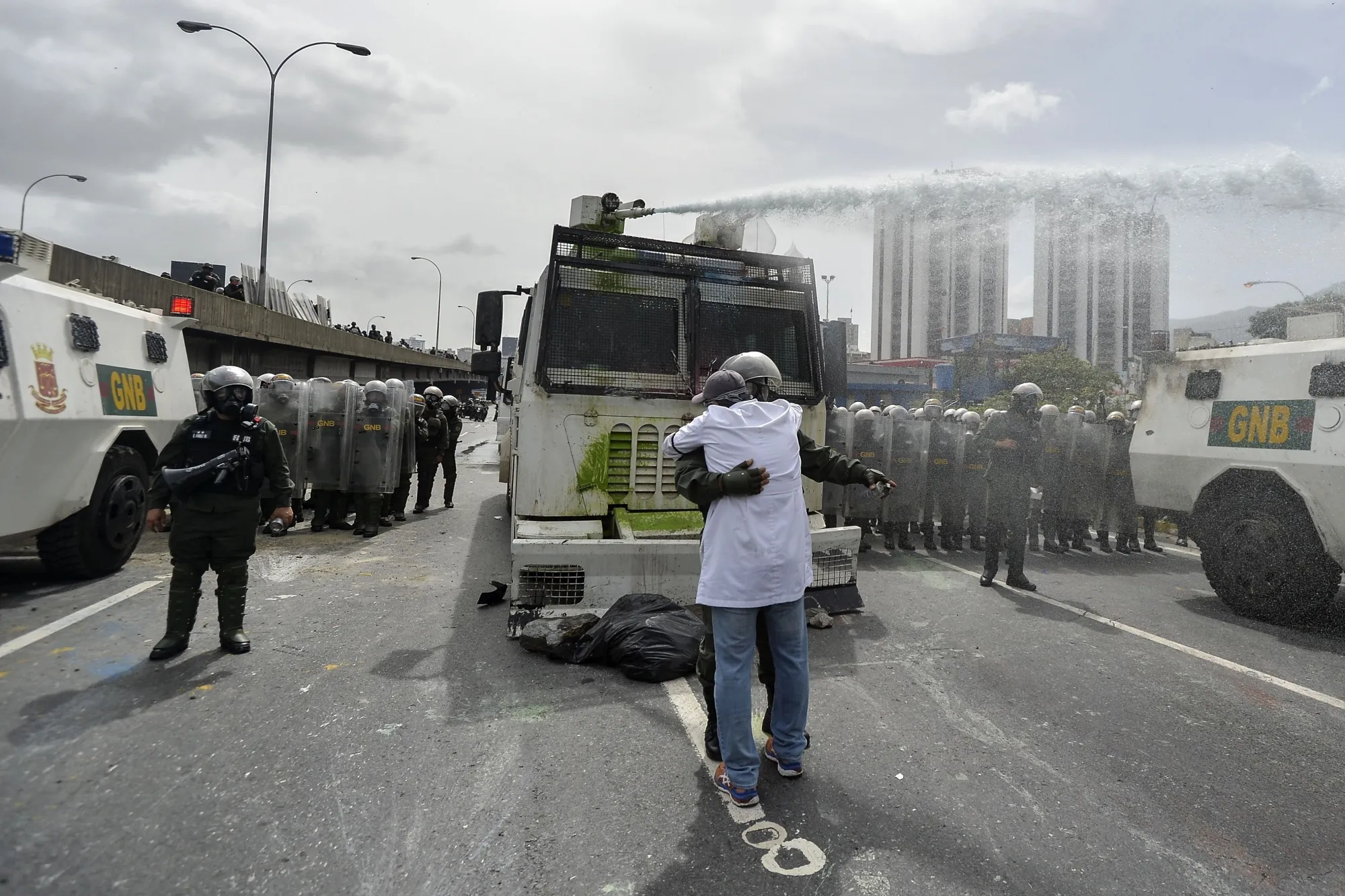 A demonstrator embraces a riot policeman during a march against Nicolas Maduro in Caracas on May 22.
