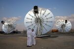 Men stand in front of solar panels at the Mohammed bin Rashid Al Maktoum Solar Park in Dubai on November 28.