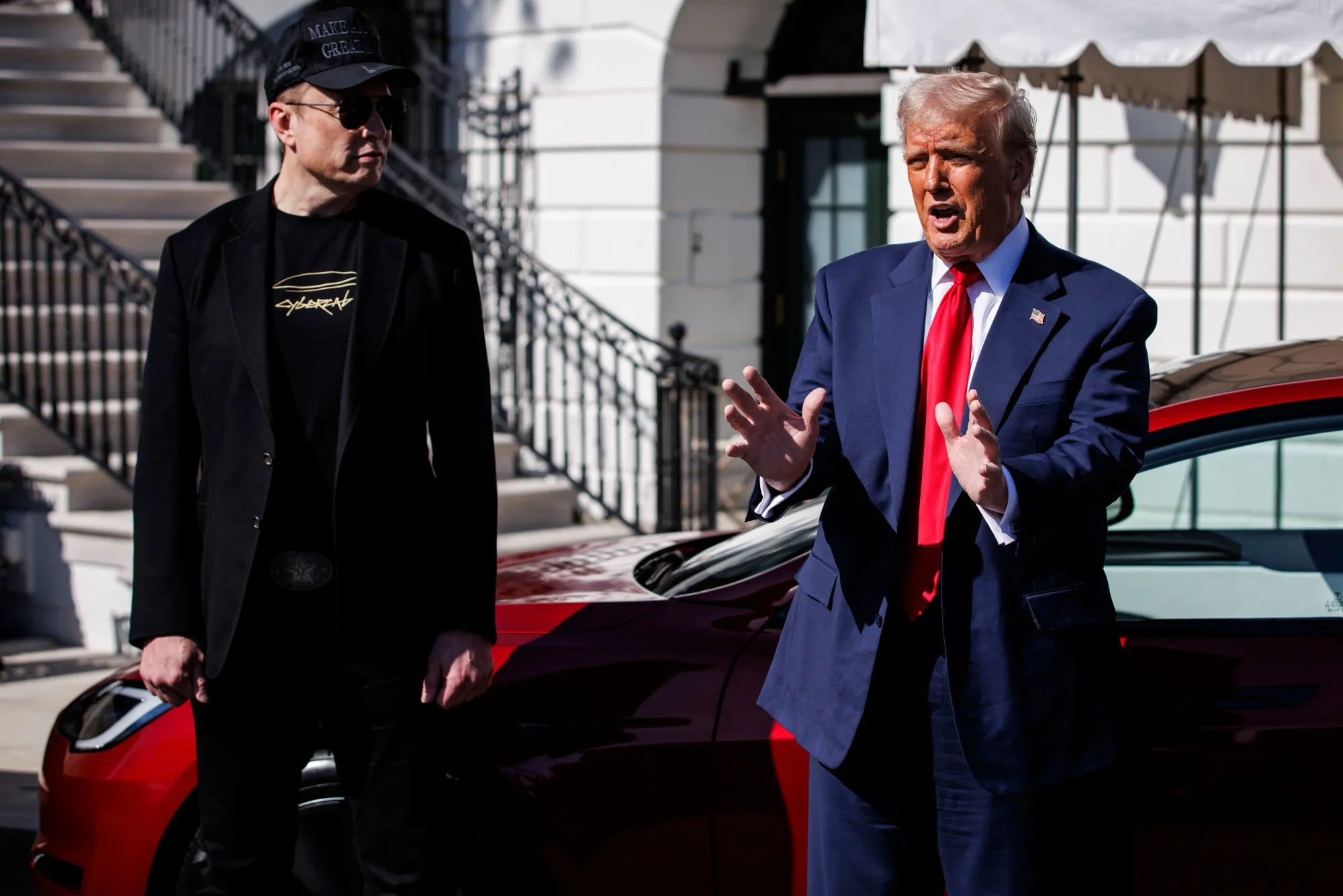 Elon Musk, left, and President Donald Trump speak to members of the media while looking at a Tesla Model S vehicle on the South Lawn of the White House in Washington, DC, on March 11.