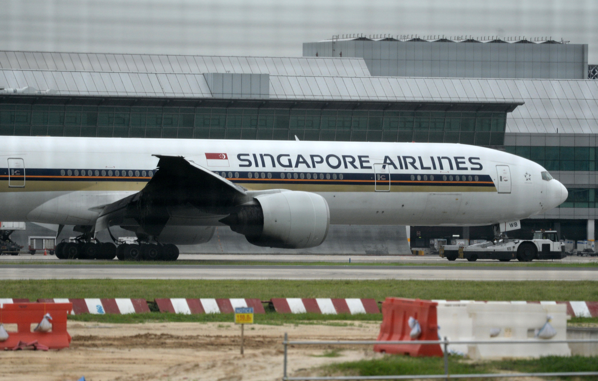 A damaged Singapore Airlines aircraft is towed at Changi airport in Singapore.
