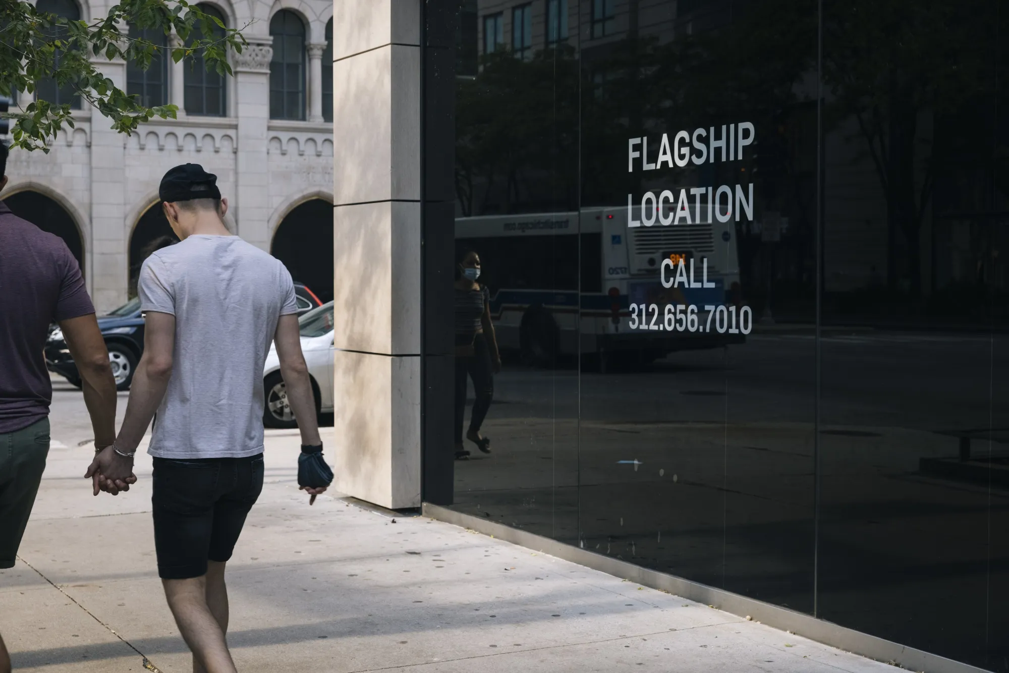 Pedestrians walk past an empty storefront on Michigan Avenue in Chicago.