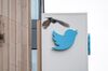 A bird flies near signage displayed outside of Twitter headquarters in San Francisco, California.