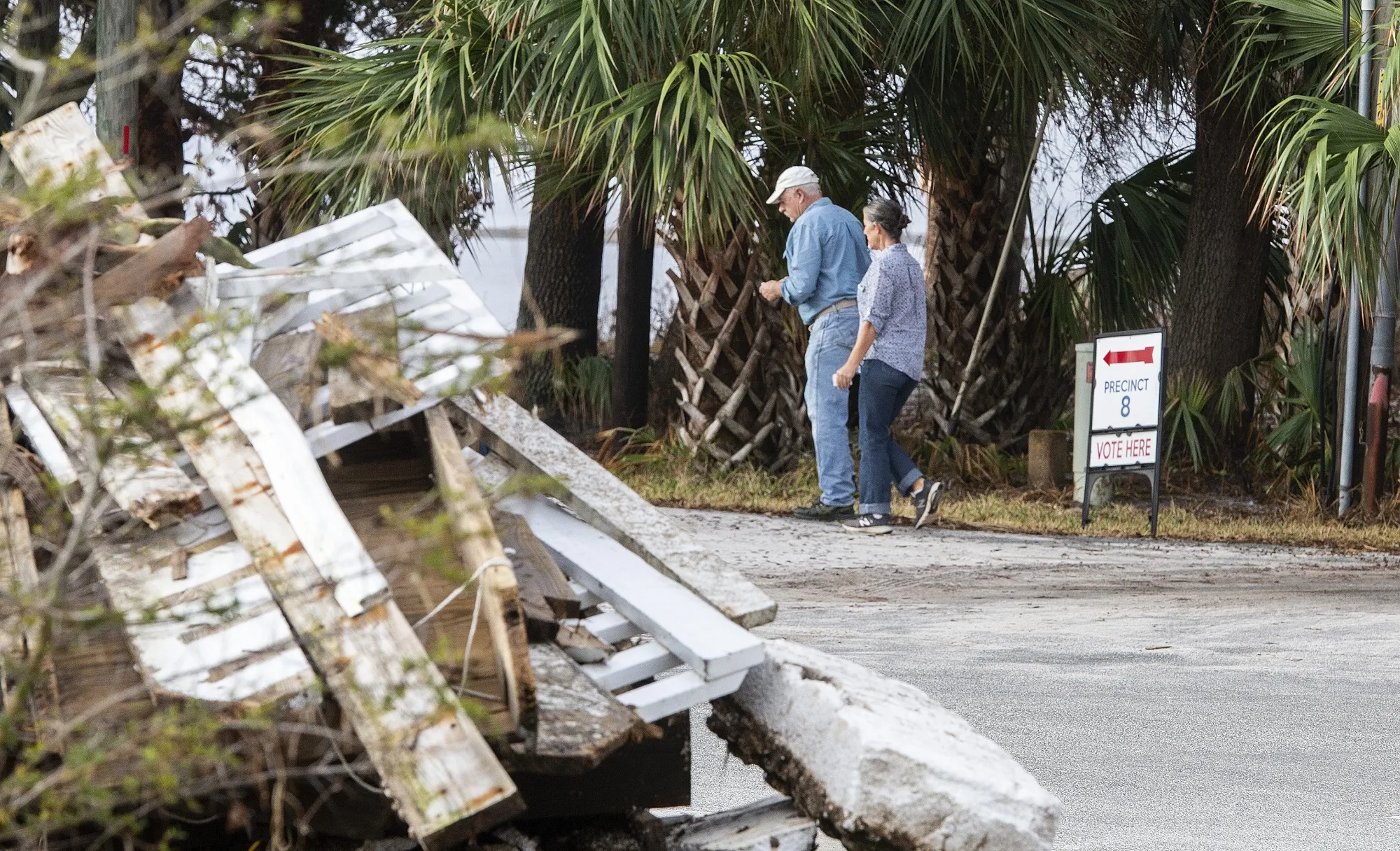 Displaced voters walk through debris to vote in a new polling location after their regular polling place was damaged by Hurricane Michael at Shell Point Beach in Wakulla Country, Florida on November 6, 2018.&nbsp;