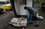 A pedestrian pauses to read the newspaper headlines outside a kiosk in Tehran, Iran, on&nbsp;May 9, 2018.