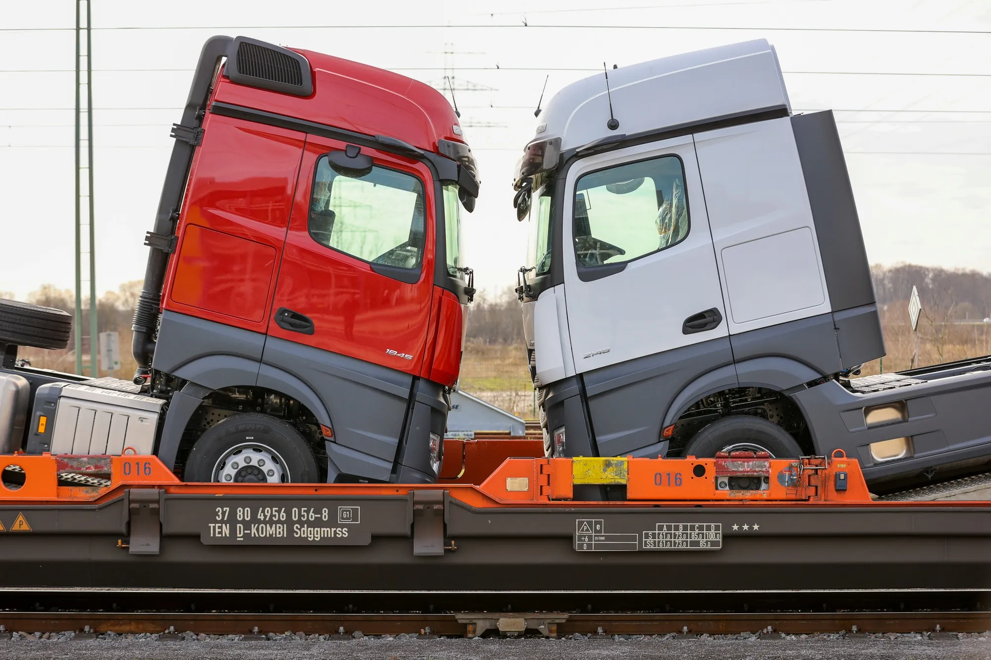 Haulage trucks loaded onto a train outside the Daimler AG truck factory in Woerth, Germany.