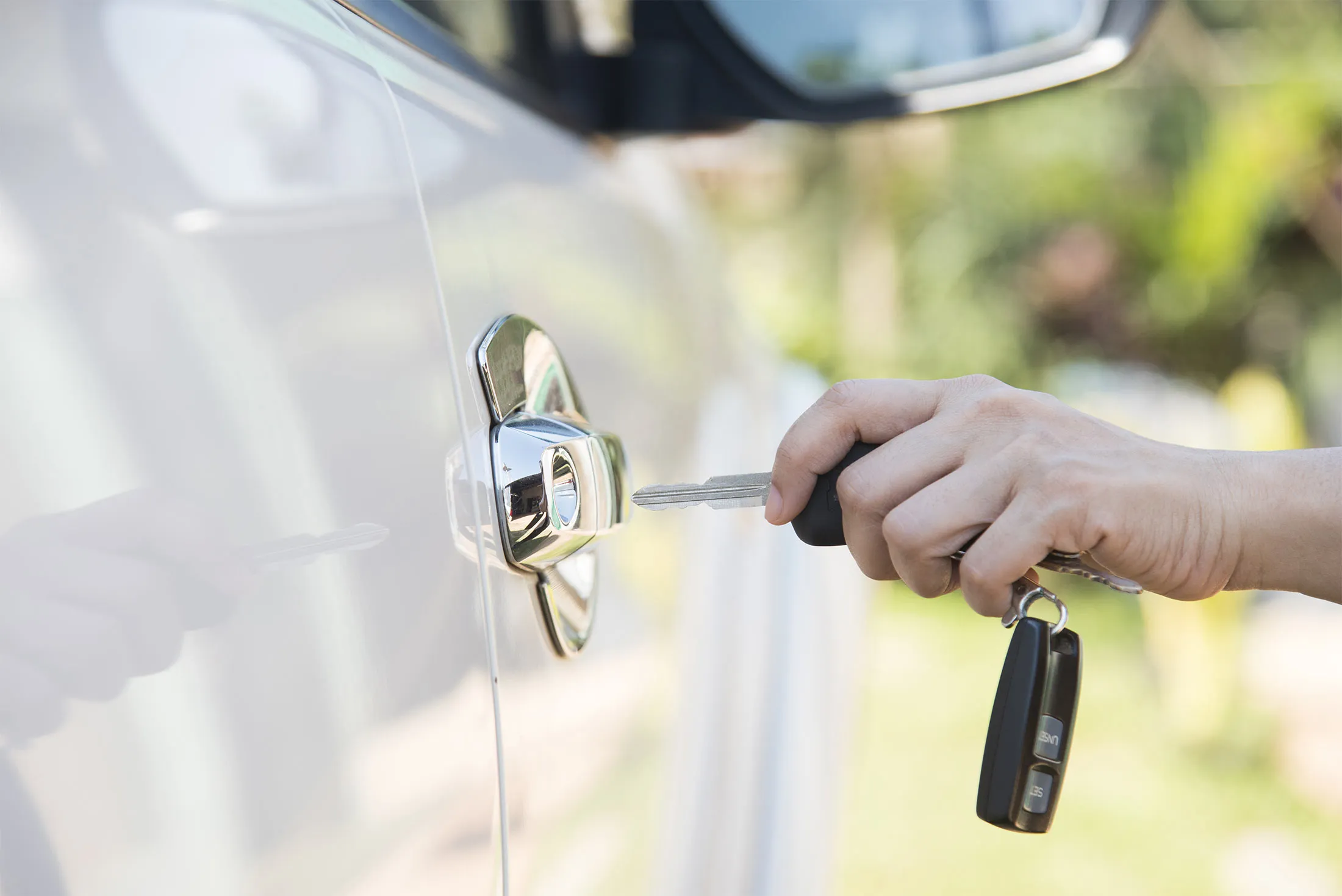 woman hand holding the remote control to unlock the car door