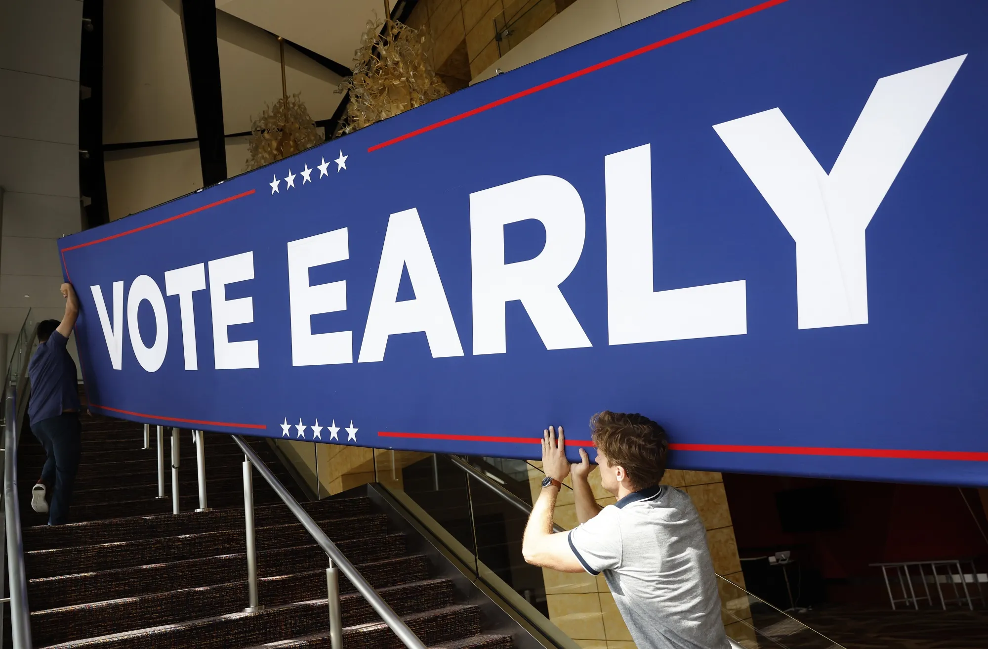 Campaign staff members&nbsp; move a sign into the hall before a rally for Donald Trump in Atlanta, Georgia on Oct. 15.