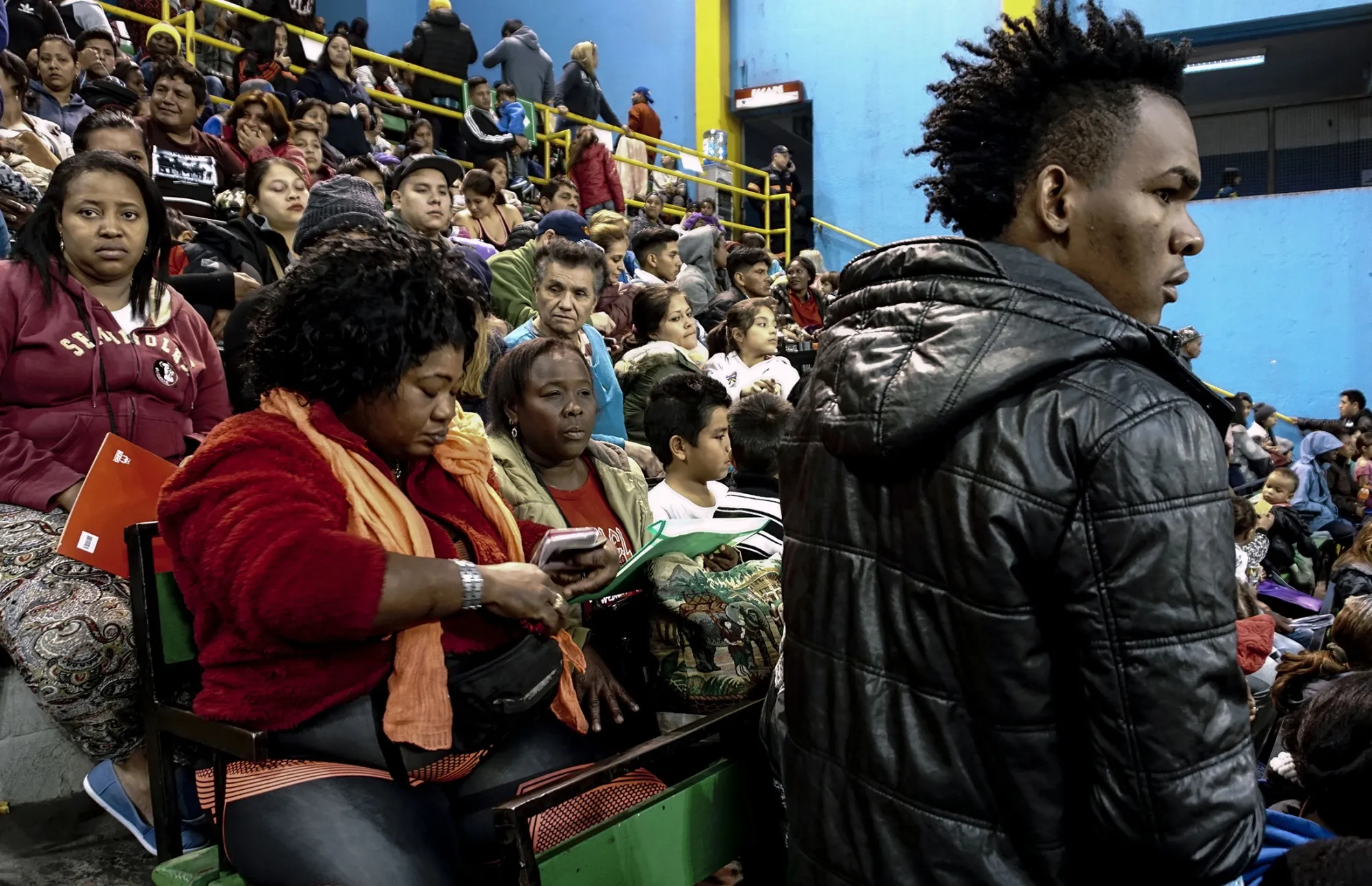 Migrants wait to legalize their status with Chilean authorities in Santiago on April 23, 2018.