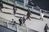 Morning commuters wearing protective masks walk on a footbridge in Tokyo, Japan, on Tuesday, Feb. 25, 2020. Japan saw a 6.3% economic contraction in the last three months of 2019, fueling criticism of Prime Minister Shinzo Abe’s decision to carry out the tax increase at a vulnerable time for the economy. After factoring in the early signs of impact from the coronavirus, analysts now believe the economy is falling into recession.
