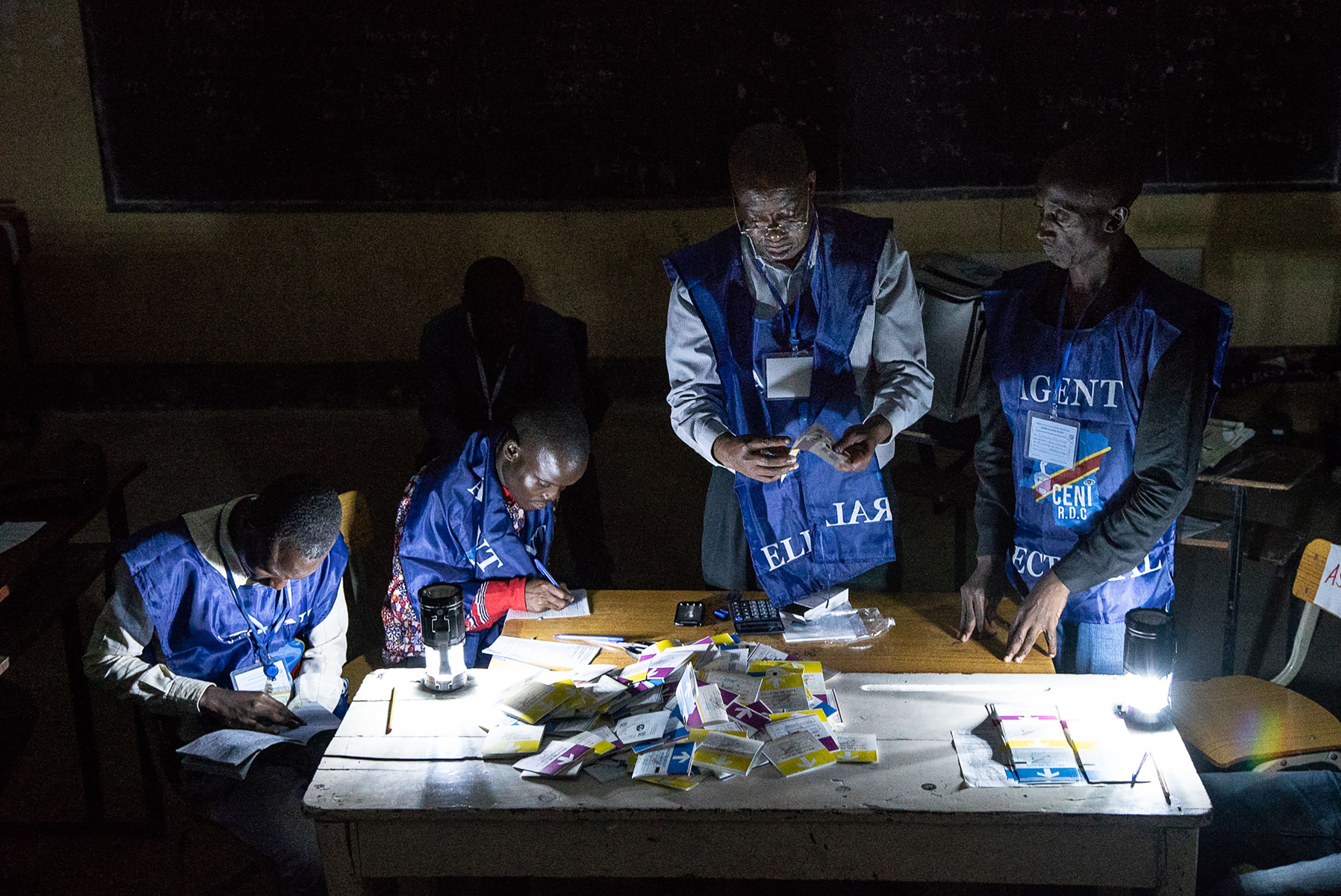 Independent National Electoral Commission (CENI) agents count votes while watched by observers at Kiwele college in Lubumbashi on Dec. 30.
