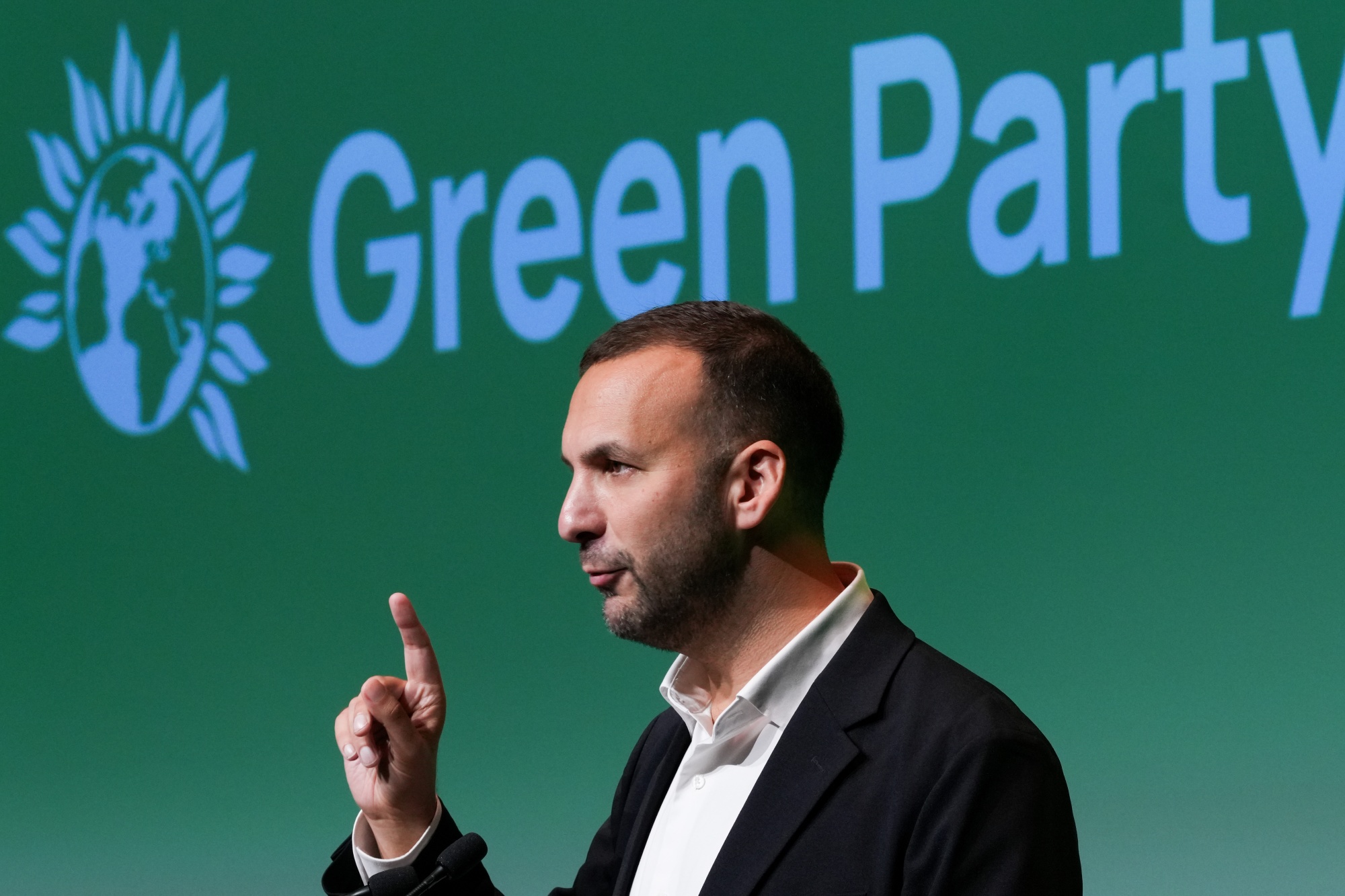 Zack Polanski, leader of the Green Party, delivers his keynote speech at the party's annual autumn conference in Bournemouth, UK, on Friday, Oct. 3, 2025. The party elected Polanski as its new leader, signaling a move to the populist left for the climate-focused group. Photographer: Carlos Jasso/Bloomberg