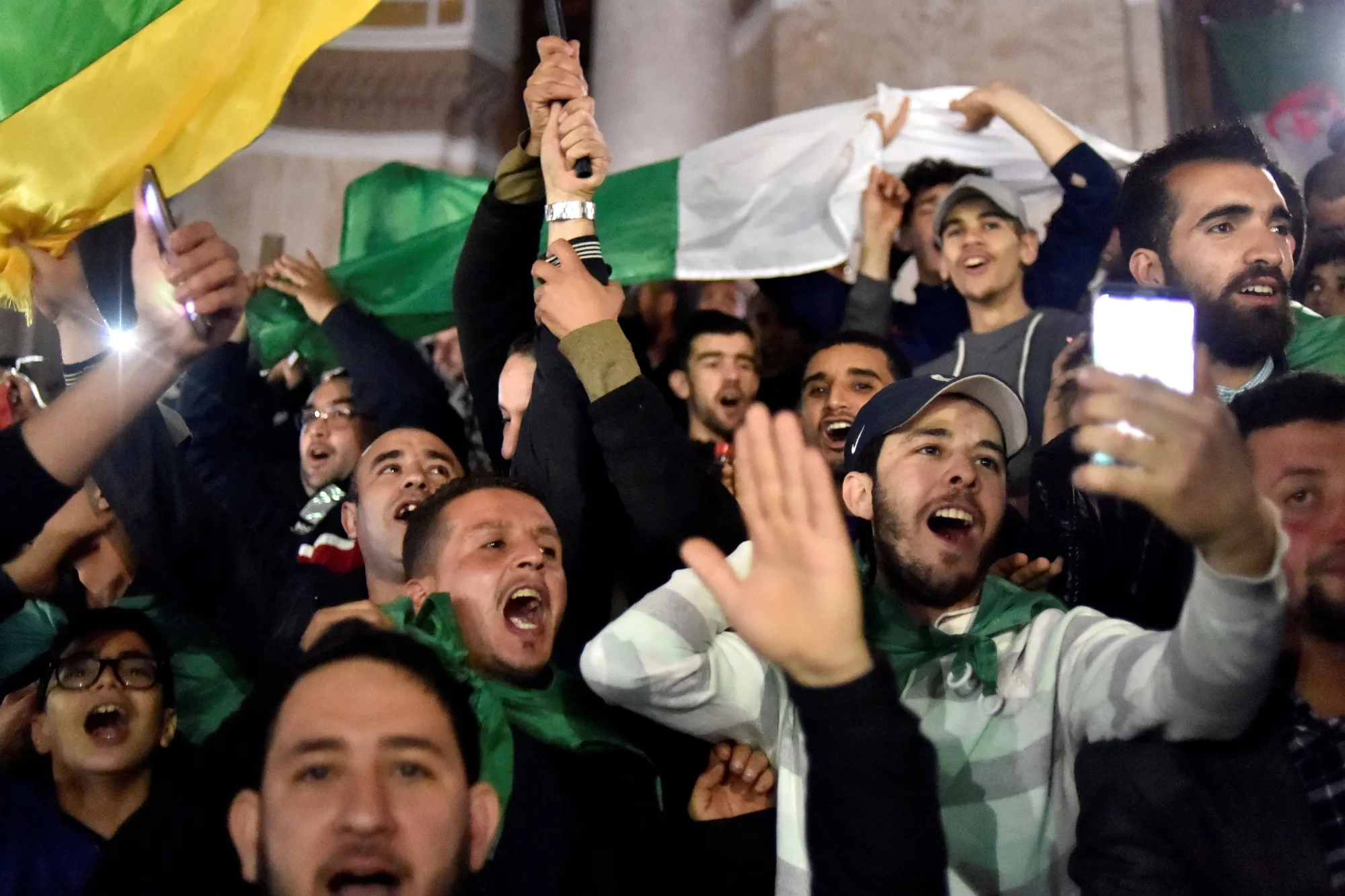 People celebrate after President Abdelaziz Bouteflika informed the Constitutional Council that he is resigning, in Algiers on April 2.