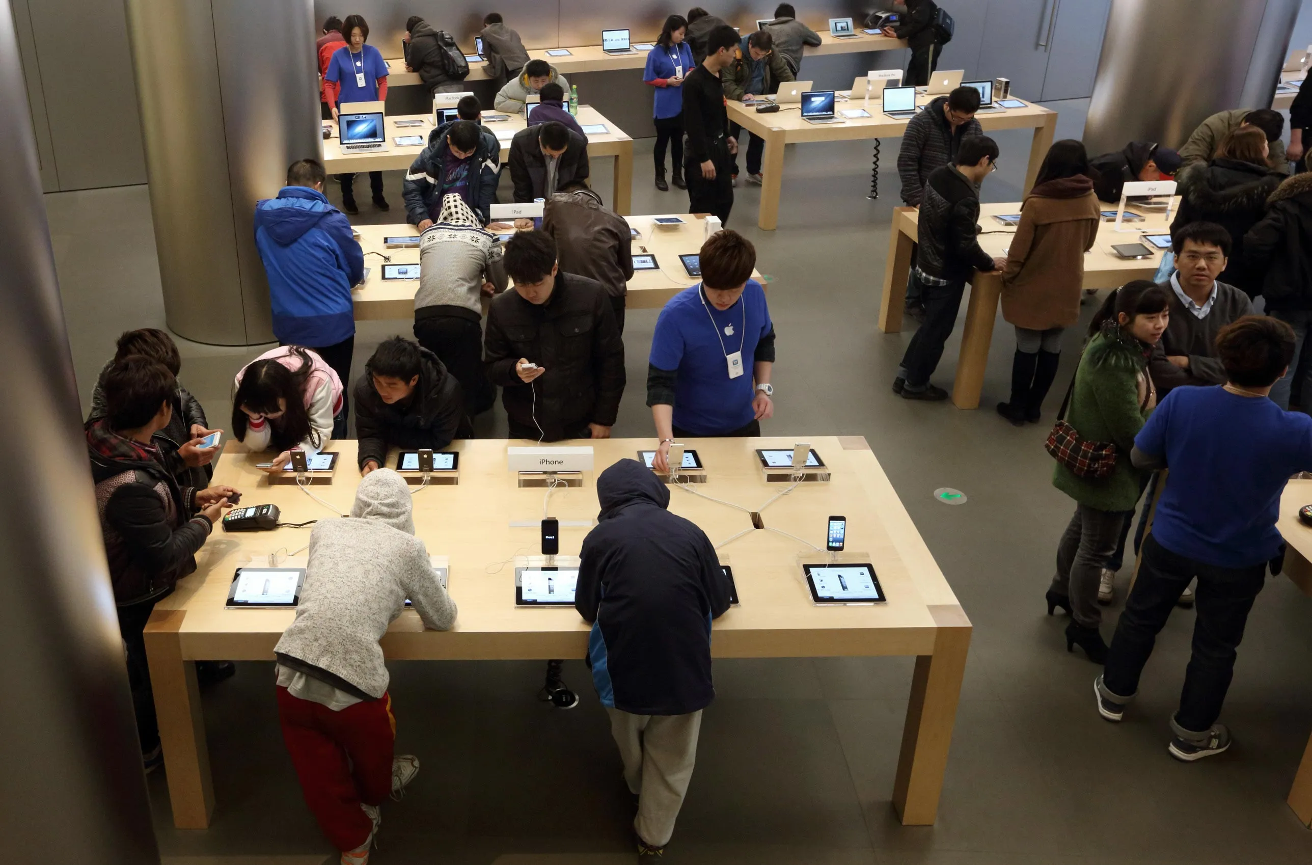 Customers try Apple products, including the iPhone, at the company's store in Beijing on March 12, 2013. Apple's Wangfujing store is the largest in Asia. Photographer: Tomohiro Ohsumi/Bloomberg